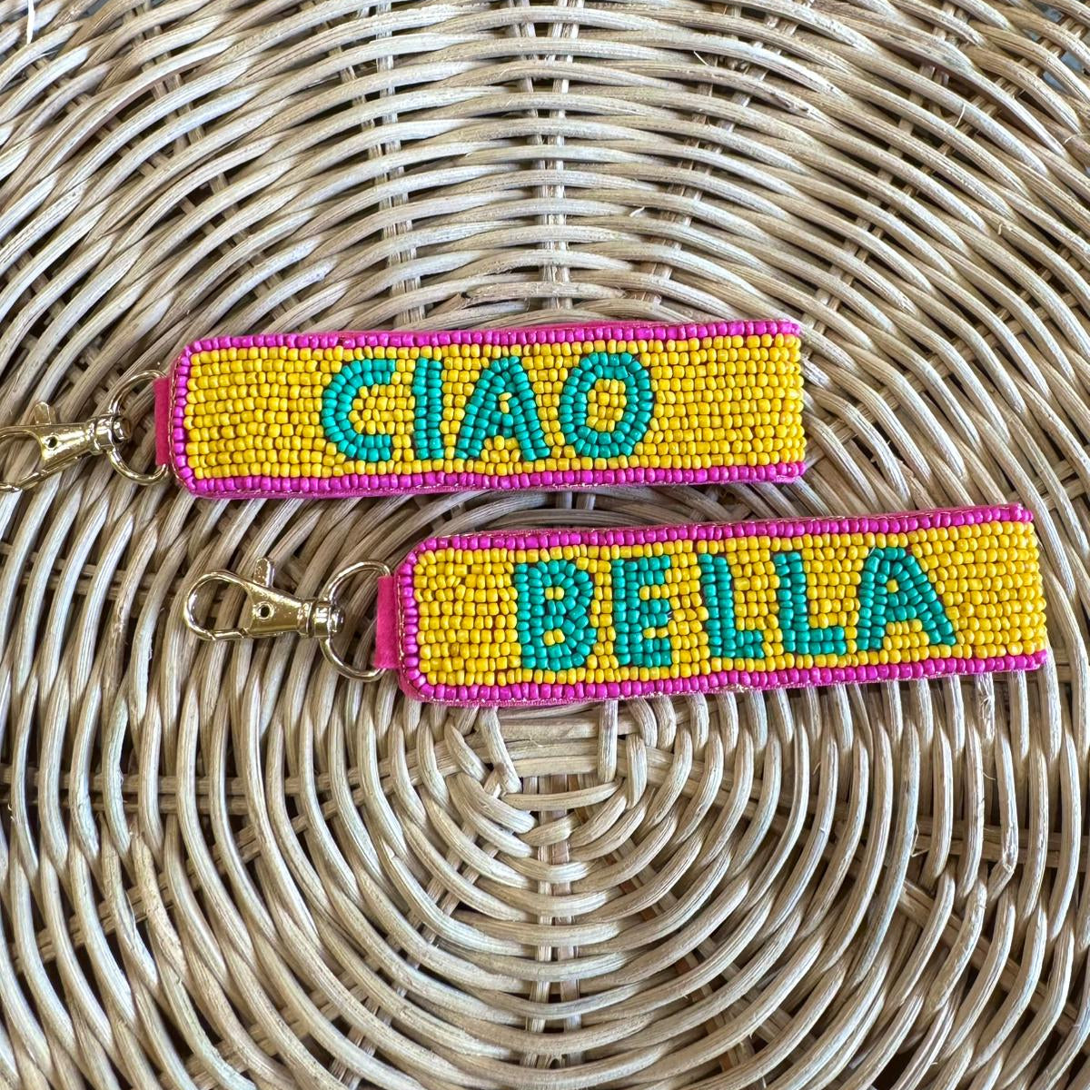 Two sided colorful keychains with 'CIAO' and 'BELLA' text on each beaded surface.